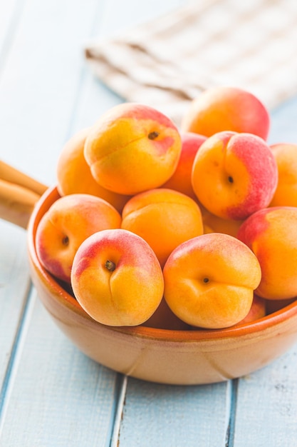 Sweet apricot fruits on blue wooden table