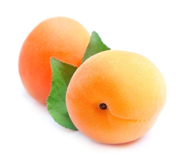 Сладкие фрукты абрикоса с листьями на белом