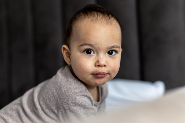 Sweet baby boy on the bed Just awake toddler Funny face of chubby child