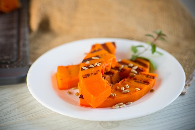 Sweet baked grilled pumpkin with seeds in a plate