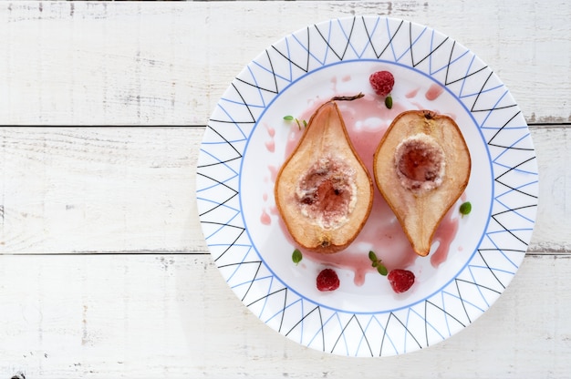 Sweet baked pear stuffed with cottage cheese with raspberry