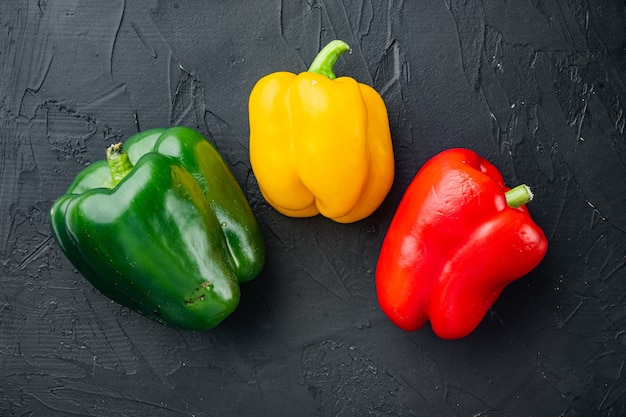 Sweet bell peppers, on black background, top view flat lay