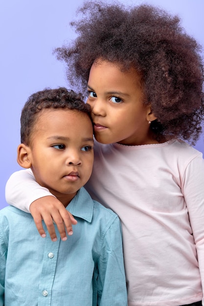 Sweet black kids brother and sister twins or siblings in casual wear embracing