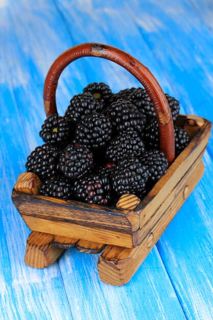 Photo sweet blackberries in wooden basket on table closeup
