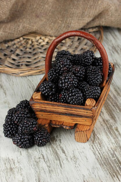 Sweet blackberries in wooden basket on table closeup