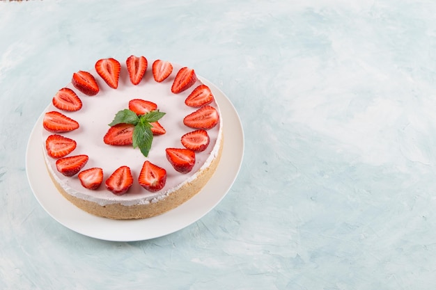 Sweet breakfast delicious cheesecake with fresh strawberries and mint homemade recipe without baking on a blue stone table Copy space