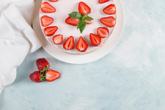 Sweet breakfast delicious cheesecake with fresh strawberries and mint homemade recipe without baking on a blue stone table Copy space