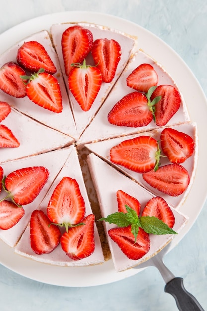 Sweet breakfast delicious cheesecake with fresh strawberries and mint homemade recipe without baking on a blue stone table Copy space