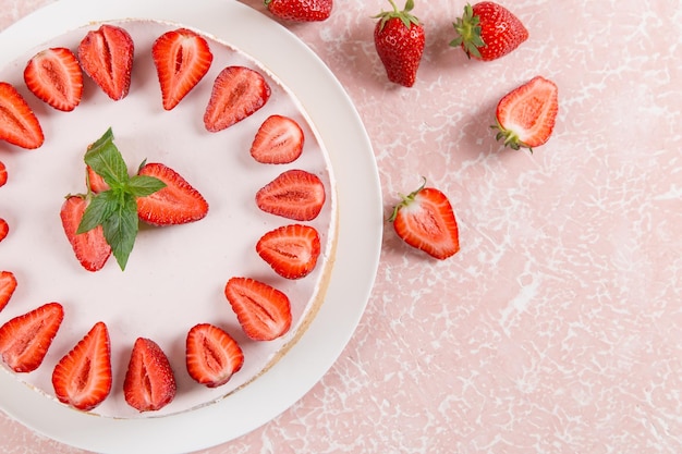 Sweet breakfast delicious cheesecake with fresh strawberries and mint homemade recipe without baking on a pink stone table Copy space