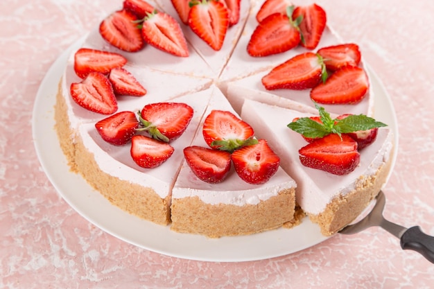 Sweet breakfast delicious cheesecake with fresh strawberries and mint homemade recipe without baking on a pink stone table Copy space