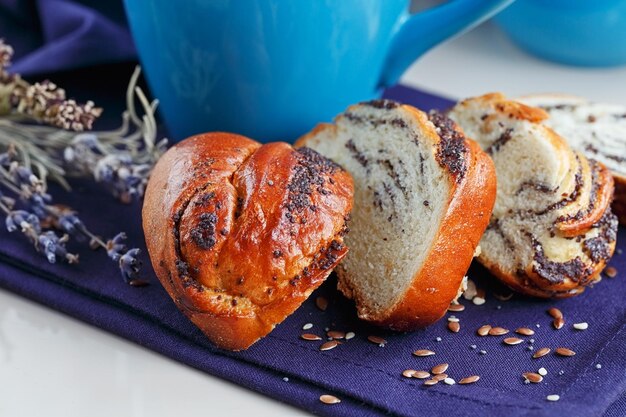 Foto dolce panino con semi di papavero con una tazza di caffè o cappuccino sul tavolo attenzione selettiva