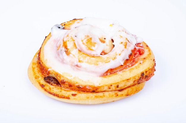 Sweet bun with raisins and white sugar icing. Studio Photo.