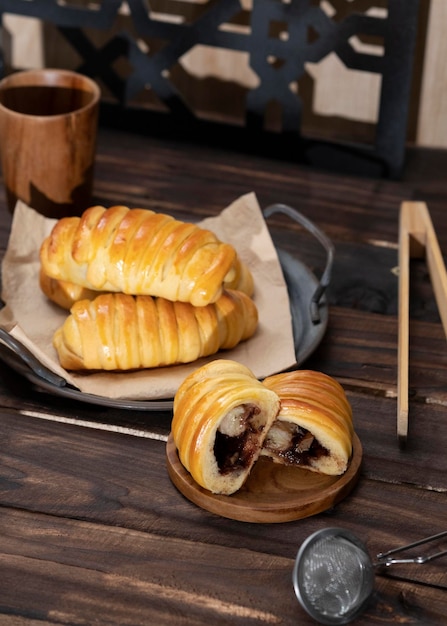 Sweet buns filled with chocolate, cheese, bananas served in a iron vintage plate. Dark background.