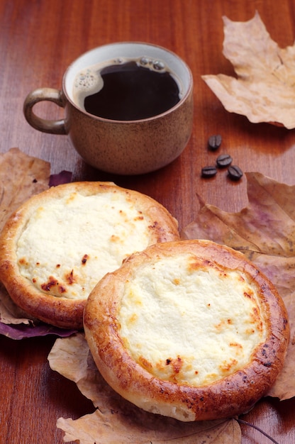 カッテージチーズとテーブルの上のコーヒーの甘いパン