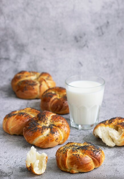 Sweet buns with poppy seeds served with milk. Selective focus.