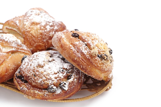 Sweet buns with raisins and apples on white background