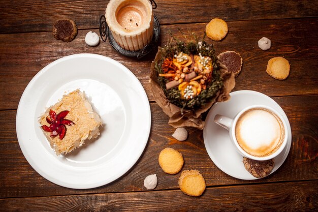 Фото Сладкий торт и капучино на праздничном деревянном столе