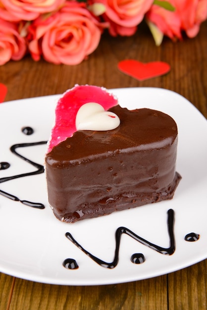 Sweet cake with chocolate on plate on table close-up