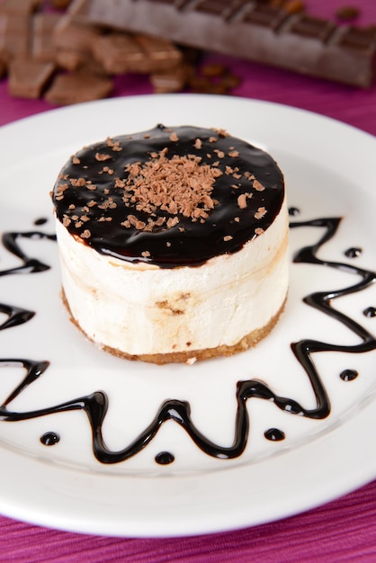 Foto torta dolce con cioccolato sulla zolla sul primo piano del tavolo