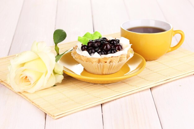 Sweet cake with cup of tea on wooden background