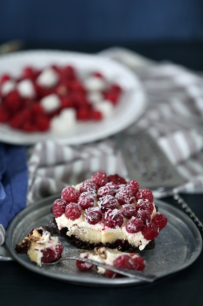 Foto torta dolce con lamponi su fondo di legno di colore