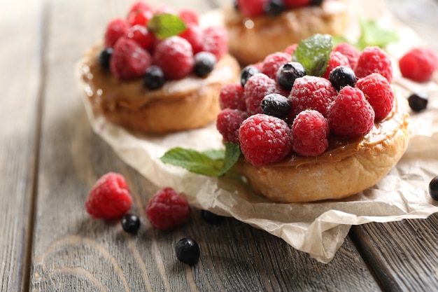 Sweet cakes with berries on table close-up