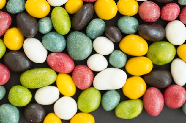 Сладкие конфеты на черном фоне Разные цветовые узоры