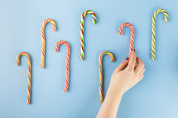 Sweet Candy canes on blue. Flat lay. Top view.