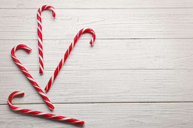 Sweet candy canes on wooden background