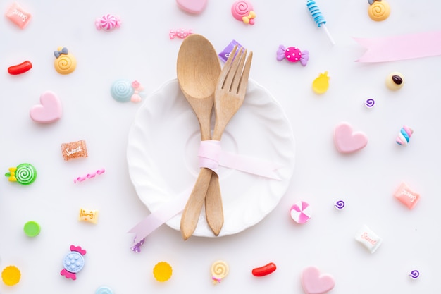 Sweet candy with spoon and fork on white background, valentines day background.