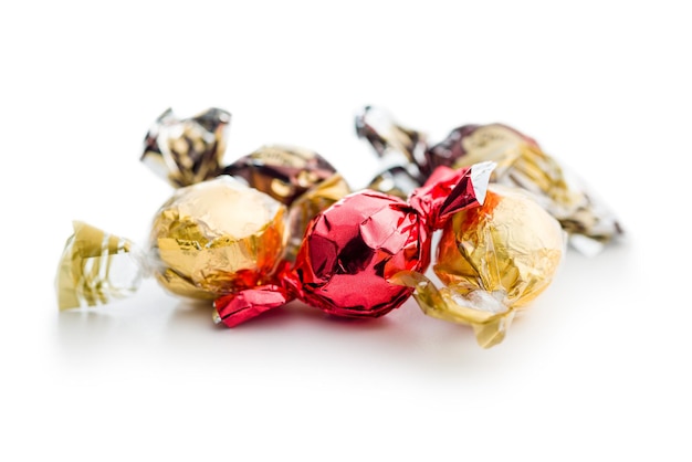 白い背景に分離されたホイルに包まれた甘いお菓子
