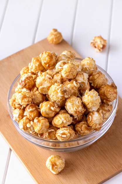 Foto popcorn al caramello dolce in una ciotola di vetro. avvicinamento. spazio luminoso.