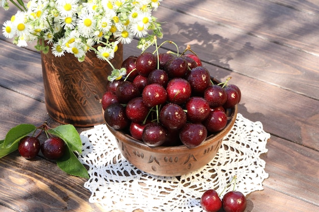 sweet cherries on wooden table in the garden