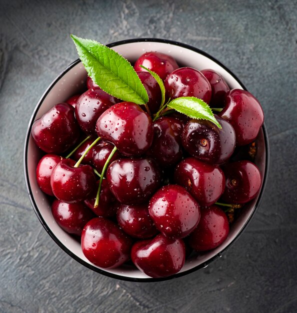 Sweet cherry fruits with water drops closeup on concrete backgrounds.