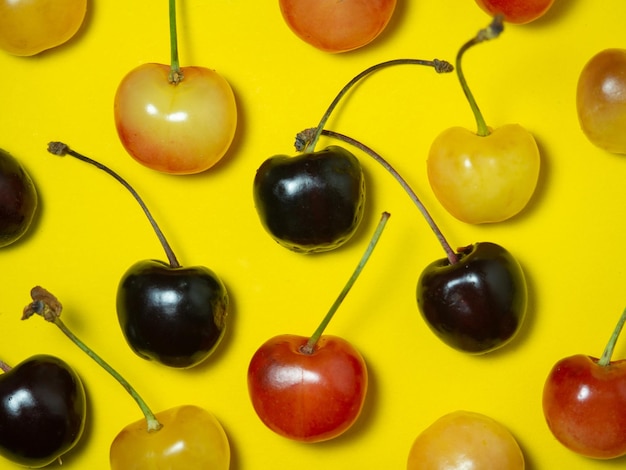 Sweet cherry with a stem on a yellow background Bright table Berries on the table