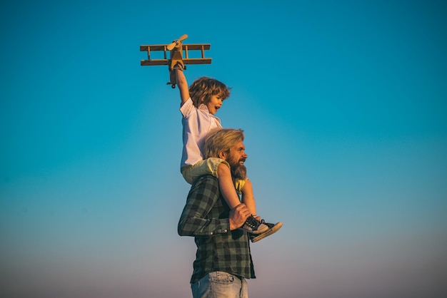 Sweet childhood Father and son playing with toy plane outdoor Family holiday parenthood Fathers day