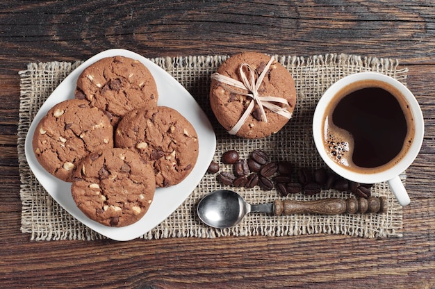写真 上からテーブルの上の朝食のためのコーヒーカップと甘いチョコレートクッキー