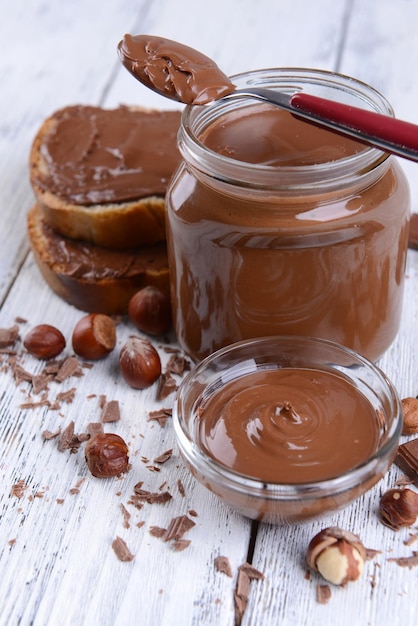 Sweet chocolate cream in jar on table closeup