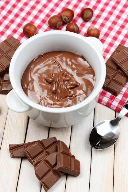 Sweet chocolate hazelnut spread with whole nuts and mint on wooden background