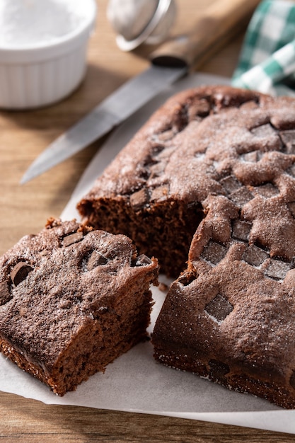 Sweet chocolate sponge cake on wooden table.