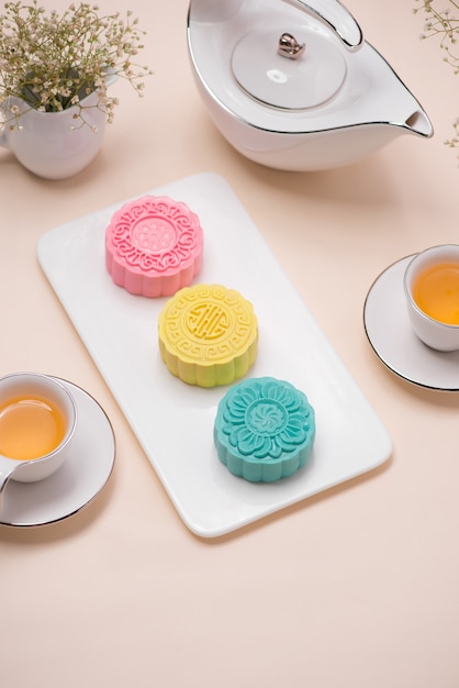 Sweet color of snow skin mooncake. Traditional mid autumn festival foods with tea on table setting.