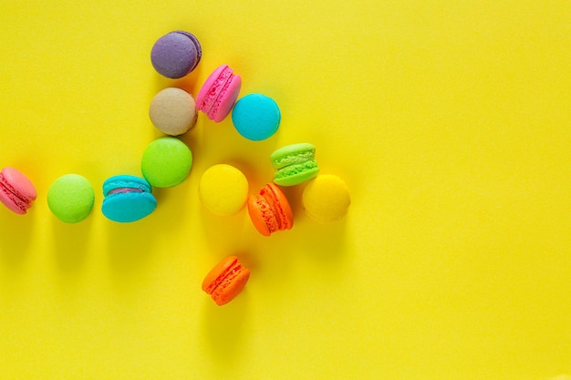 Sweet and colorful french macaroons or macaroon on yellow background