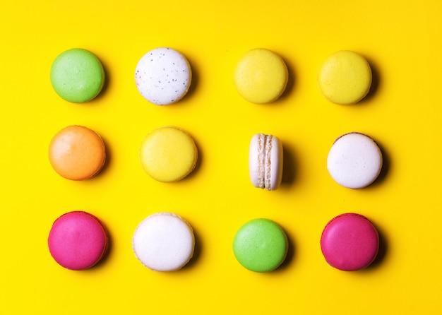 Sweet colorful macaroons on yellow background