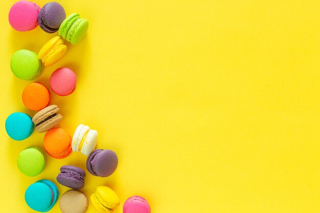 Sweet colorful macaroons on yellow background