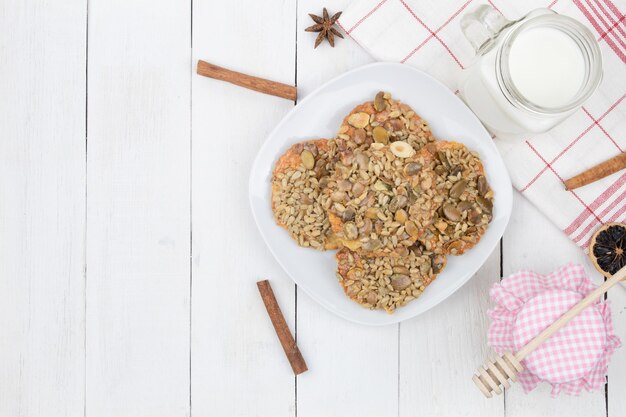 Sweet cookies and milk with honey on a wooden background