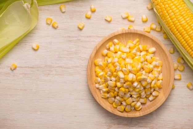 Photo sweet corn seeds on a wooden plate