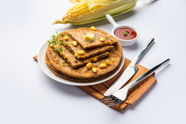 Sweet corn stuffed paratha or parotha served in a plate Indian flatbread recipe made filling makai