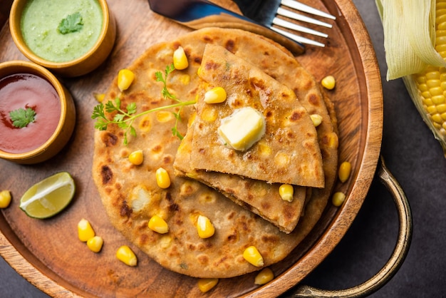 Sweet corn stuffed paratha or parotha served in a plate Indian flatbread recipe made filling makai