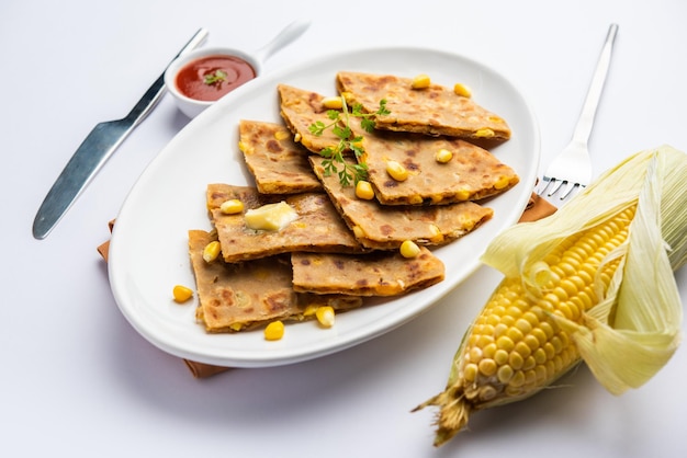 Sweet corn stuffed paratha or parotha served in a plate Indian flatbread recipe made filling makai