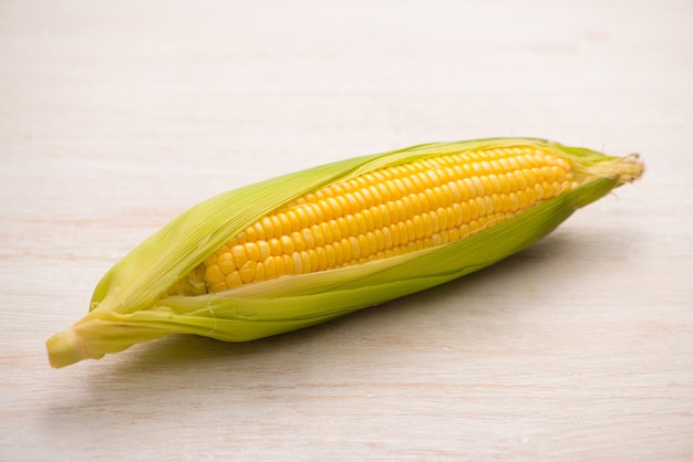 Sweet corns. Fresh corn on cobs on wooden table.